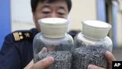 A Chinese border policeman displays confiscated vanadium bound for North Korea at a checkpoint in Dandong, Liaoning province. Chinese border police have seized 70 kg (154 lb) of the strategic metal vanadium bound for North Korea, foiling an attempt to smu