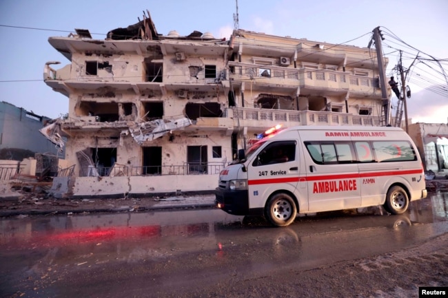 An ambulance passes in front of buildings damaged when a suicide car bomb exploded, targeting a Mogadishu hotel in a business center in Maka al-Mukaram street, Mogadishu, Somalia, March 1, 2019.