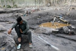 Seorang kakek beristirahat di atas batu saat mengunjungi daerah yang diyakini sebagai tempat cucunya dimakamkan setelah letusan Gunung Semeru di Sumberwuluh. (Foto: Reuters)