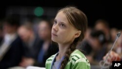 Swedish climate activist Greta Thunberg listens to speeches before addressing a plenary of U.N. climate conference at the COP25 summit in Madrid, Spain, Wednesday, Dec. 11, 2019. (AP Photo/Paul White)