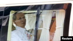 FILE - Thailand's King Bhumibol Adulyadej sits in a vehicle as he leaves Siriraj Hospital for the Grand Palace to join a ceremony marking Coronation Day in Bangkok, May 5, 2015.