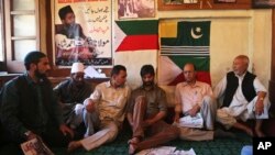 Kashmiri separatist leader and Jammu Kashmir Liberation Front (JKLF) Chairman, Yasin Malik, center with beard, sits with party workers at the JKLF’s office in Srinagar, India, Aug. 19, 2014. 