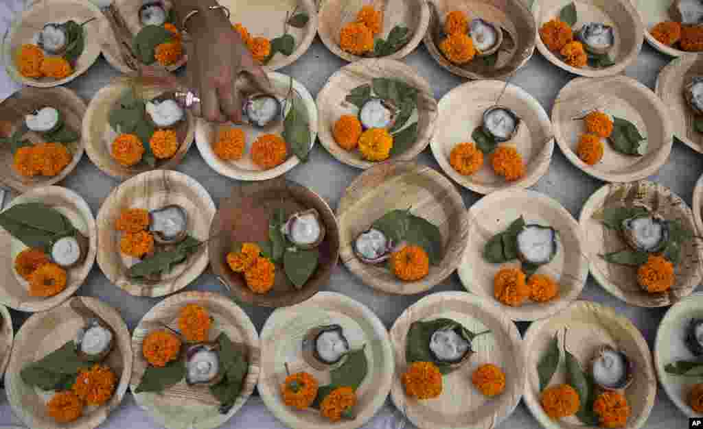 A girl arranges earthen lamps to perform rituals during the inaugural ceremony of a five-day long Namami Brahmaputra festival in Gauhati, India. This is the first year of the festival.