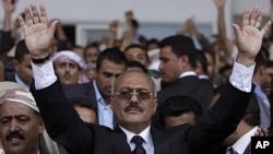 Yemeni President Ali Abdullah Saleh waves to his supporters, not pictured, during a rally in Sana'a, April 15, 2011