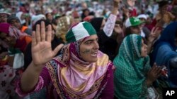A supporter of Tahir ul-Qadri, Sufi cleric and leader of political party Pakistan Awami Tehreek (PAT) ,reacts as she listens to her leader's speech in front of the Parliament house building during the Revolution March in Islamabad, Aug. 28, 2014.