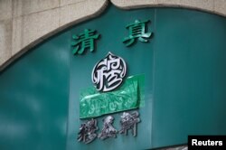 Papan nama sebuah restoran halal yang menggunakan aksara China, tampak ditutup kain di Niujie, Beijing, China, 19 Juli 2019. (Foto: Reuters)