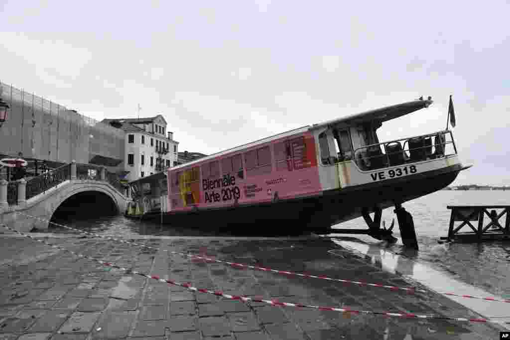 A stranded ferry boat lies on its side, in Venice, Italy The mayor of Venice is blaming climate change for flooding in the historic canal city that has reached the second-highest levels ever recorded.