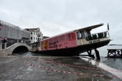 A stranded ferry boat lies on its side, in Venice, Wednesday, Nov. 13, 2019.