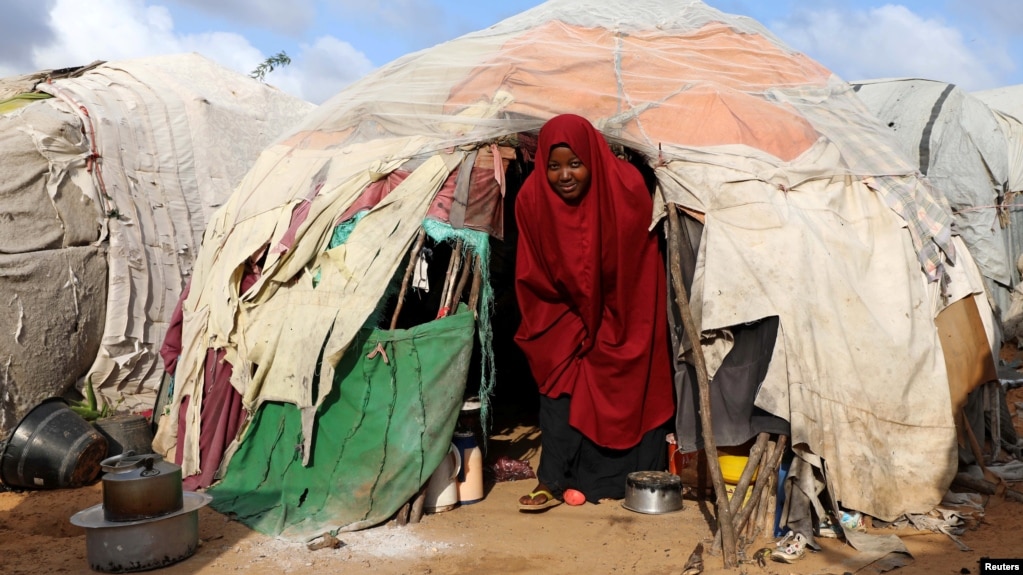 FILE - A Somali woman walks out from her makeshift shelter at a camp for the internally displaced people outside Mogadishu, Somalia, Aug. 28, 2018.