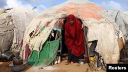 FILE - A Somali woman walks out from her makeshift shelter at a camp for the internally displaced people outside Mogadishu, Somalia, Aug. 28, 2018.