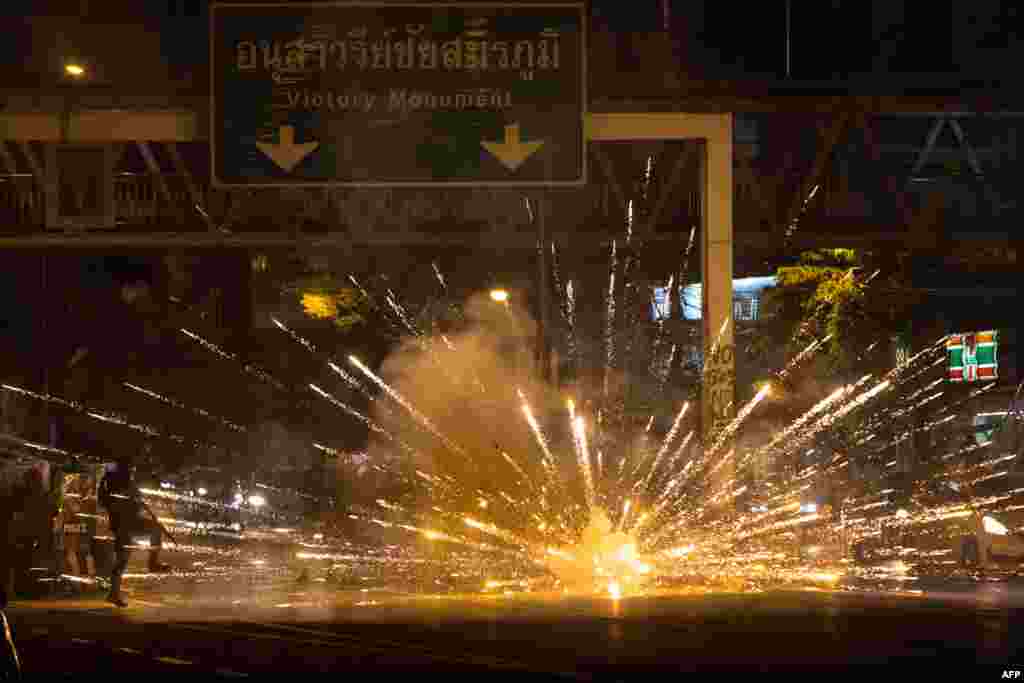 Fireworks, thrown by protesters, explode in front of a line of police during a demonstration against Thai Prime Minister Prayut Chan-O-Cha and his government&#39;s handling of the Covid-19 crisis in Bangkok.