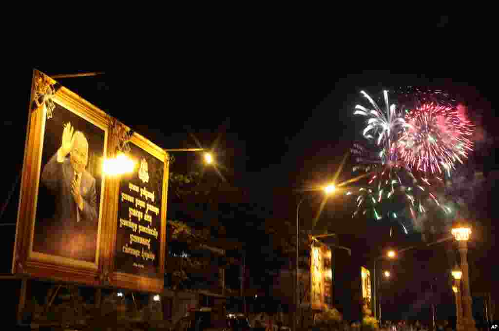 Fireworks explode behind a poster of the late Cambodian King Norodom Sihanouk as his body is cremated in Phnom Penh, Cambodia, Monday, Feb. 4, 2013. Hundreds of thousands of mourners gathered in Cambodia's capital Monday for the cremation of Sihanouk, the revered "King-Father," who survived wars and the murderous Khmer Rouge regime to hold center stage in the Southeast Asian nation for more than half a century.