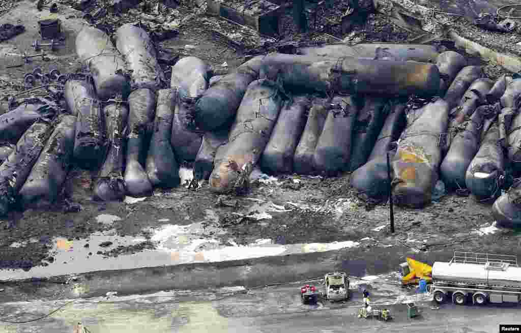 A firefighter stands close to the remains of a train wreckage in Lac-Megantic, Canada. A driverless, runaway fuel train that exploded in a deadly ball of flames in the center of a small Quebec town started rumbling down an empty track just minutes after a fire crew had extinguished a blaze in one of its parked locomotives, an eyewitness said.