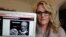 Angela Ricketts poses with a screen shot of a message she received from a group claiming to be Islamic State supporters, in Bloomington, Ind., April 9, 2018. 