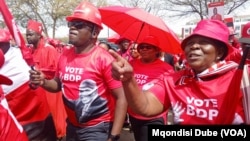 Botswana Democratic Party supporters wearing shirts displaying the portrait of President Mokgweetsi Masisi dance outside the High Court of Botswana in Gaborone, Sept, 28, 2024. 