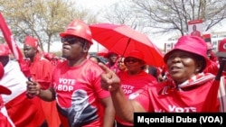 Botswana Democratic Party supporters wearing shirts displaying the portrait of President Mokgweetsi Masisi dance outside the High Court of Botswana in Gaborone, Sept, 28, 2024. 