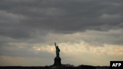 FILE - Cloudy skies hang over the The Statue of Liberty as seem from the Staten Island Ferry near New York City, US, on Dec. 17, 2018. 