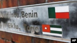FILE - The flags of the nations of Benin and Togo, the west African homes of the survivors of the slave ship Clotilda, remain on display on a monument at what was the Africatown Welcome Center in Mobile, Ala., Jan. 29, 2019. 