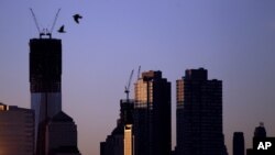 Dos pájaros vuelan a la salida del sol, con el fondo de la Torre Uno del Centro de Comercio Mundial, que podría convertirse en el edificio más alto de EE.UU., este lunes 30 de abril de 2012.