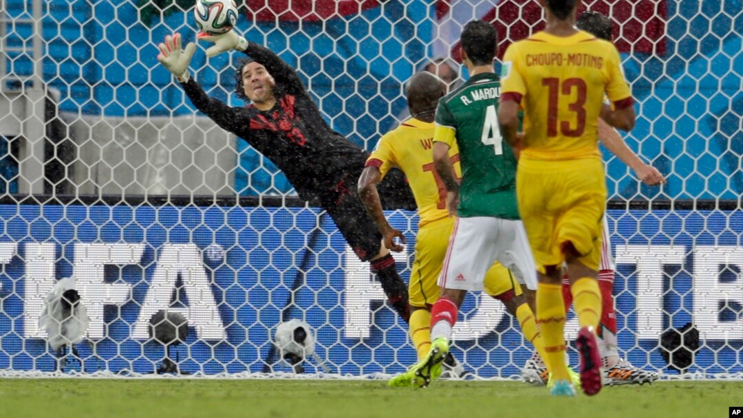 El portero de México Guillermo Ochoa evita un gol de Camerún.