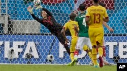 El portero de México Guillermo Ochoa evita un gol de Camerún.