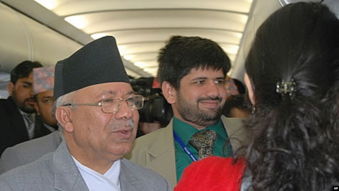 Prime Minister Madhav Kumar Nepal (L) greets fellow passengers aboard a commercial flight from Bhutan to Kathmandu, 30 Apr 2010