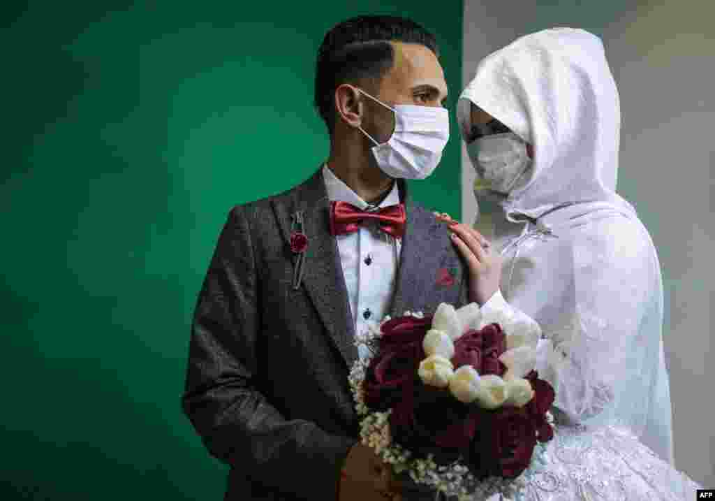 Palestinian groom Mohamed abu Daga and his bride Israa wear face masks amid the COVID-19 epidemic, during a photoshoot before their wedding ceremony in Khan Yunis in the southern Gaza Strip, March 23, 2020.