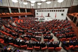 FILE - Turkish lawmakers vote on a bill that allows troop deployment to Libya, at the Parliament in Ankara, Jan. 2, 2020.
