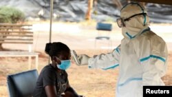 Vérification des températures lors du confinement national pour aider à freiner la propagation du coronavirus, dans un centre de dépistage à Harare, Zimbabwe, le 30 avril 2020.