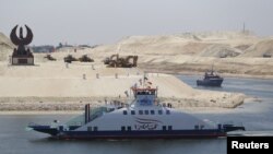 The ship 'Long Life Egypt' crosses a new section of the Suez Canal in Ismailia, Egypt, Aug. 6, 2015. The canal was extended in hopes of powering an economic turnaround. But toll revenues have fallen in September, dampening hopes that a new parallel waterway will boost the economy in the immediate future.