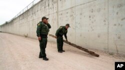 Agentes de la Patrulla Fronteriza retiran una escalera usada por migrantes para cruzar un muro cerca del cruce fronterizo de Hidalgo, Texas, el 4 de mayo de 2023.