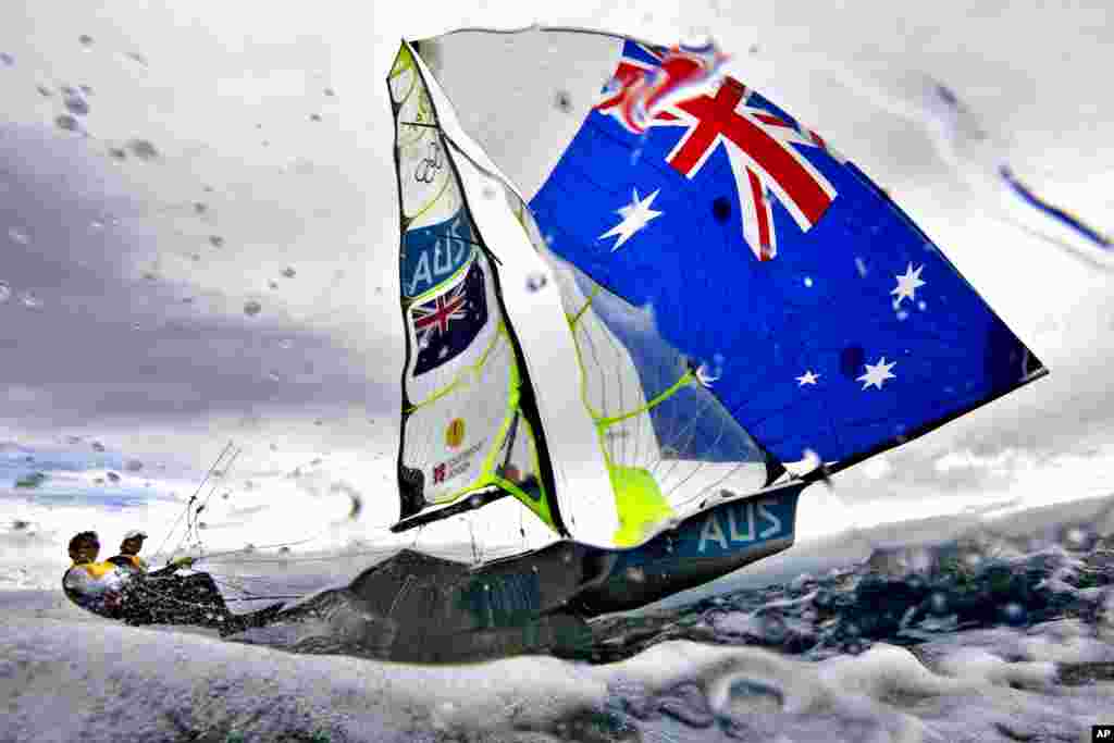 Los australianos Nathan Outteridge and Iain Jensen practican antes de comenzar la carrera de veleros.