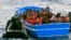 In this photo released by the Italian Navy on May 22, 2014, a fishing boat filled with migrants receives aid from an Italian Navy motor boat. 