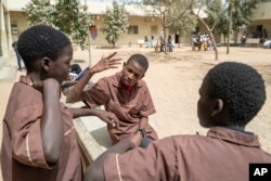 Mouhamed Sall, who is deaf, communicates by sign with his classmates at the Guinaw Rail Sud public high school in Pikine, Senegal, Monday, March 18, 2024. (AP Photo/Sylvain Cherkaoui)