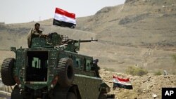 A police trooper mans a machine gun atop an armored personnel carrier near the Presidential Palace in Sana'a, Syria, May 13, 2011