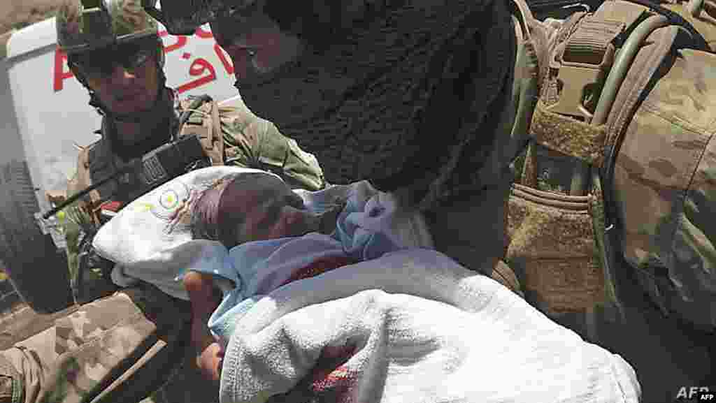 아프가니스탄 카불 다시트-에-바르치 병원에서 무장괴한의 공격 사건이 있은 후 보안군이 신생아를 안전한 곳으로 대피시키고 있다. 