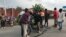 Les gens regardent une fissure sur la route causée par des tremblements de terre comme des répliques après l'éruption du volcan du mont Nyiragongo près de Goma, en République démocratique du Congo, le 26 mai 2021.