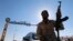 A member of Libyan forces holds a weapon as he sits on a car in front of the gate at Zueitina oil terminal in Zueitina, west of Benghazi, Libya, Sept. 14, 2016. 
