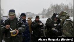 Alexei Vergunov (center) has a meal with others during a charity event organized by Caritas in Omsk on December 26, 2019. Vergunov said he has learned to be on the lookout for ill-wishers. He once saved the life of his friend Alexander after a group of teenagers set him on fire.