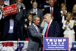 FILE - Then-Republican presidential candidate Donald Trump welcomes Nigel Farage, left, ex-leader of the British UKIP party, to speak at a campaign rally in Jackson, Miss., Aug. 24, 2016.
