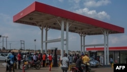 ARQUIVO: Pessoas fazem fila com bidões para comprar combustível na estação de serviço Biwi Triangle Petroda em Lilongwe, no Malawi, a 1 de outubro de 2021.