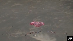 FILE - In this photo released by Xinhua News Agency, a capsule carrying Chinese astronauts touches down at the Dongfeng landing site in northern China's Inner Mongolia Autonomous Region, April 30, 2024.