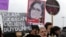 A Turkish woman holds a poster of murdered 20-year-old student Ozgecan Aslan at a protest in Ankara Feb. 18, 2015. The placards read: "End the killings of women" and "Islam (Aysenur Islam, Family Affiars minister), did you hear Ozgecan's scream?"