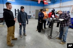 Payton Lane, 19, left, and Boone Williams, 20, talk during a second-year apprentice training program class at the Plumbers and Pipefitters Local Union 572 facility in Nashville, Tenn. The union is working with young adults who graduated from high school during the pandemic and are taking career routes other than college for its apprentice program. (AP Photo/Mark Zaleski)