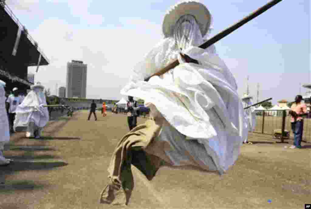 Eyo masquerades dance through Tafawa Balewa Square in Lagos, Nigeria, Saturday, Nov. 26, 2011, to honor the death of a prominent Lagos Chief Yusufu Abiodun Oniru. The shouting masquerades carry sticks and sometimes hit people who break traditional rules l