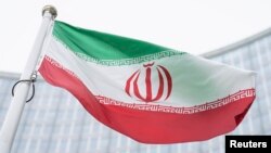 Bendera Iran berkibar di depan gedung International Center dengan markas besar Badan Tenaga Atom Internasional, IAEA, di Wina, 24 Mei 2021. (Foto: AP)