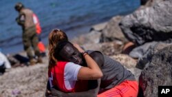 A migrant is comforted by a member of the Spanish Red Cross near the border of Morocco and Spain, at the Spanish enclave of Ceuta. Thousands of Moroccans took advantage of relaxed border control in their country to swim or paddle into European soil. 