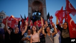 Orang-orang meneriakkan slogan-slogan saat mereka berkumpul dalam unjuk rasa pro-pemerintah di Lapangan Taksim, Istanbul pusat (16/7) (foto: AP Photo/Emrah Gurel)