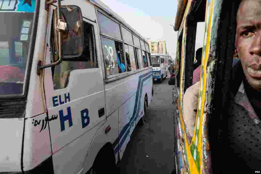 An Indian-made Tata passes a car rapide in Dakar, Senegal. Authorities are planning to retire the colorful minibuses by late 2018. (R. Shryock/VOA)