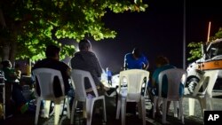 Neighbors remain outdoors using camping tents and portable lights for fear of possible aftershocks on their first night after a 6.4-magnitude earthquake struck in Guanica, Puerto Rico, Jan. 7, 2020.